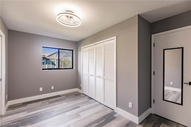 unfurnished bedroom with a closet and light hardwood / wood-style floors