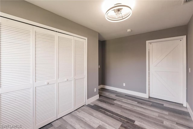 unfurnished bedroom featuring a closet and light wood-type flooring