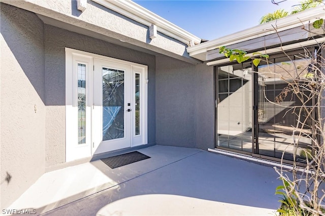 view of exterior entry featuring a patio