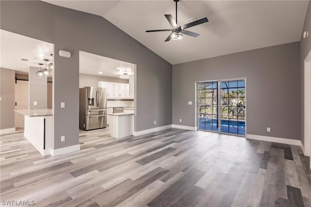 unfurnished living room featuring high vaulted ceiling, ceiling fan, and light hardwood / wood-style floors