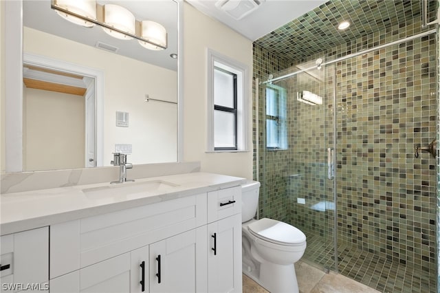 bathroom featuring tile patterned flooring, vanity, toilet, and a shower with door