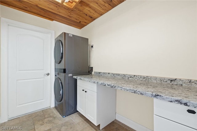 washroom with cabinets, stacked washing maching and dryer, and wood ceiling