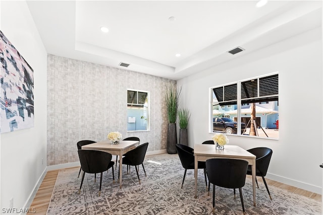 dining area featuring a tray ceiling and hardwood / wood-style floors