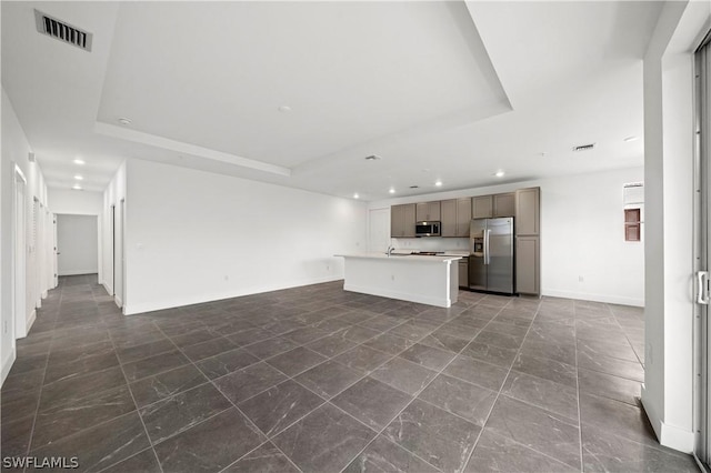 unfurnished living room with a raised ceiling