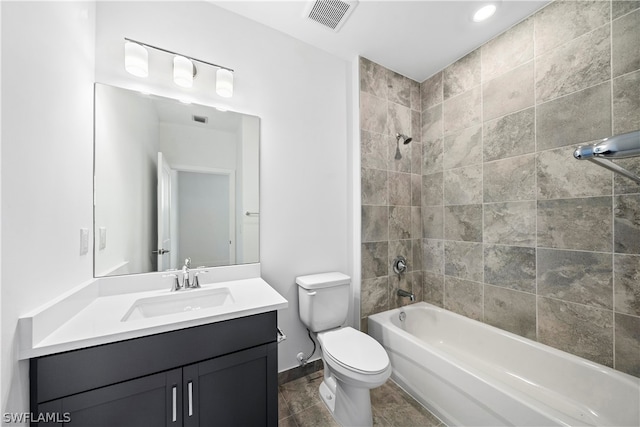 full bathroom featuring vanity, tiled shower / bath combo, and toilet