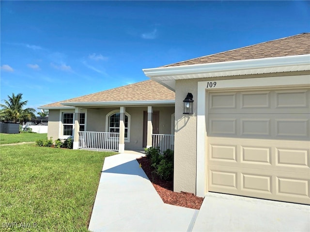 view of front facade with a front yard, a porch, and a garage