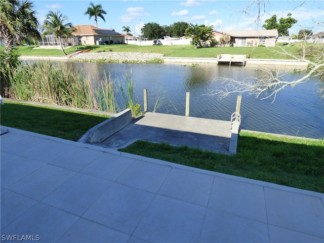 dock area with a water view and a yard