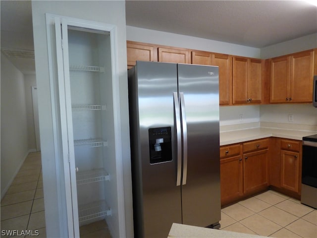 kitchen featuring light tile floors and stainless steel appliances