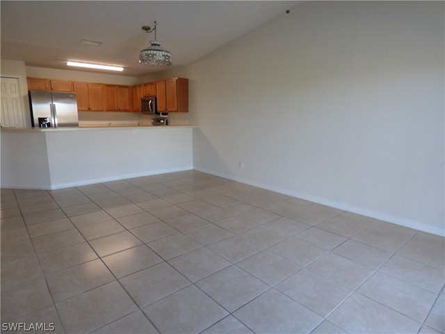 unfurnished living room featuring a chandelier and light tile flooring