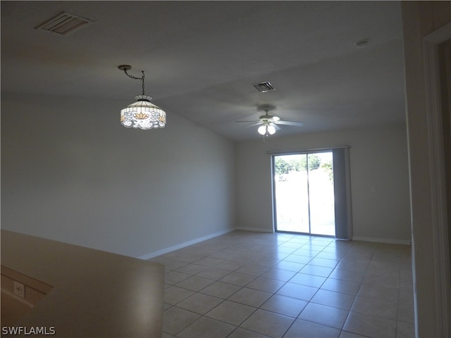 unfurnished room with ceiling fan with notable chandelier and light tile floors