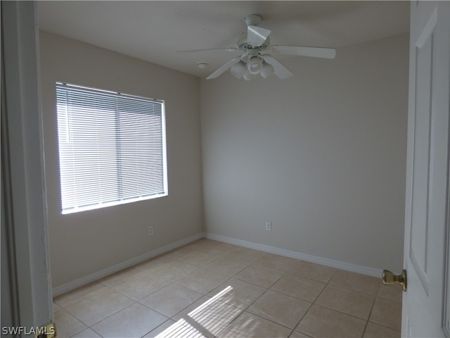 tiled empty room with ceiling fan and a healthy amount of sunlight