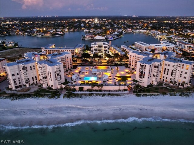 aerial view at dusk featuring a water view