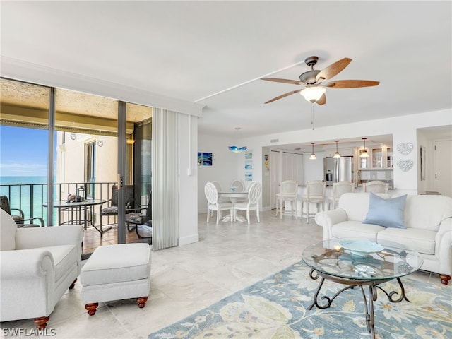 living room with a water view and ceiling fan