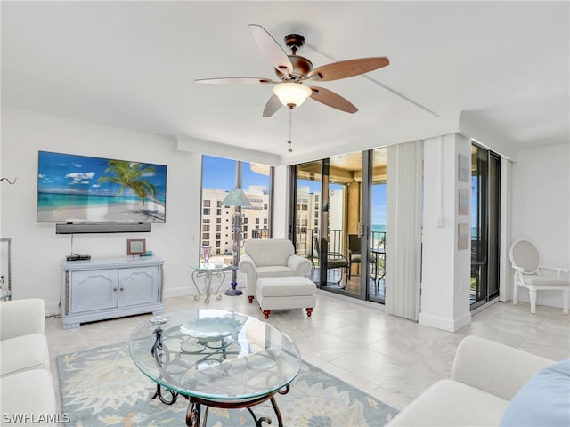 living room featuring ceiling fan, a wall of windows, and light tile patterned floors