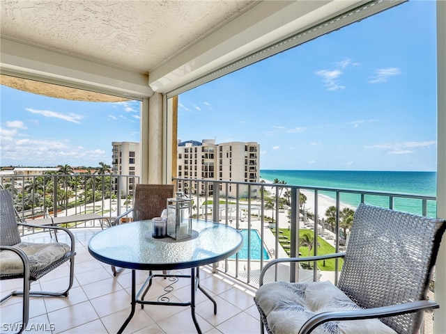 balcony featuring a water view and a beach view