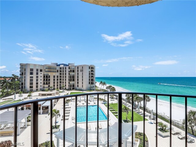 balcony with a water view and a view of the beach