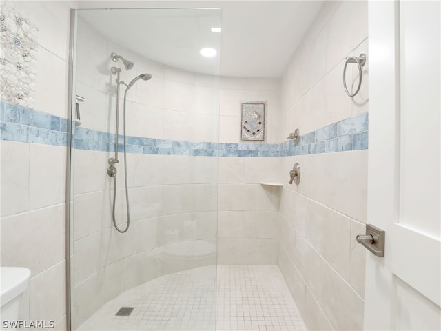 bathroom with toilet and tiled shower