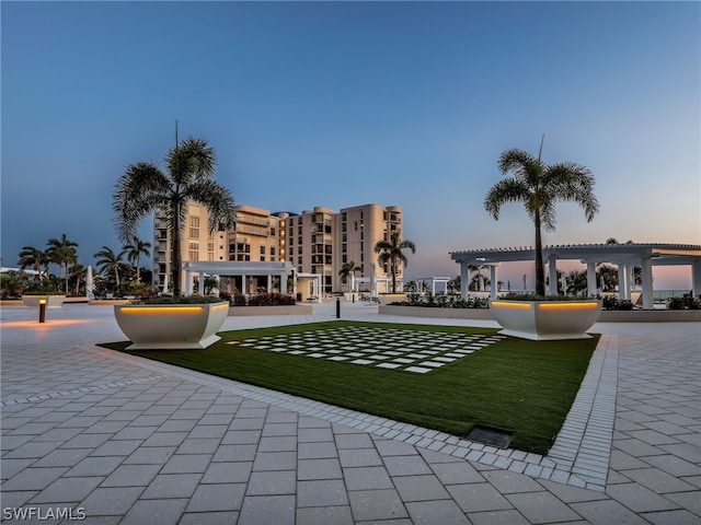 view of community featuring a yard and a pergola