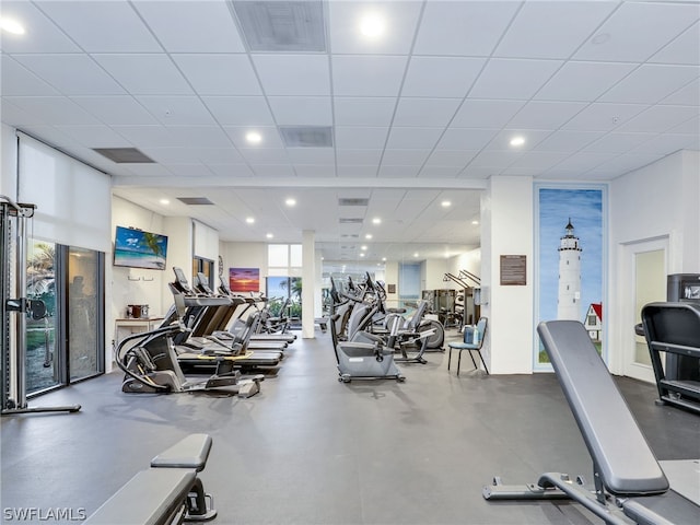 gym featuring a paneled ceiling and expansive windows