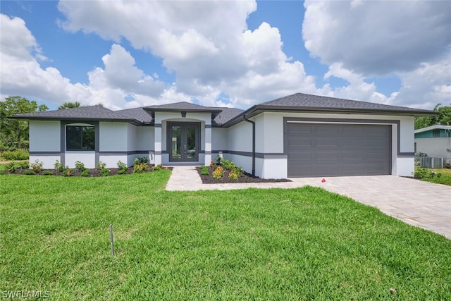 view of front of property featuring french doors, a garage, central AC, and a front lawn