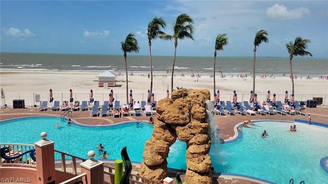 view of swimming pool featuring a beach view and a water view