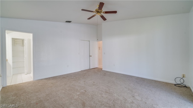 empty room featuring ceiling fan, light colored carpet, and lofted ceiling