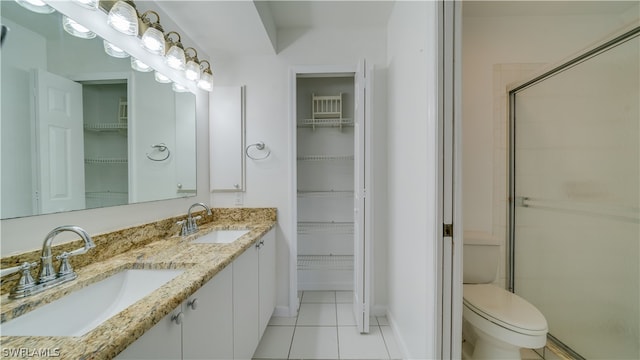 bathroom with tile flooring, double vanity, and toilet