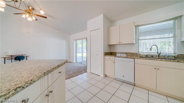 kitchen featuring vaulted ceiling, light stone counters, white dishwasher, light carpet, and sink