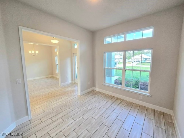 unfurnished room with a chandelier