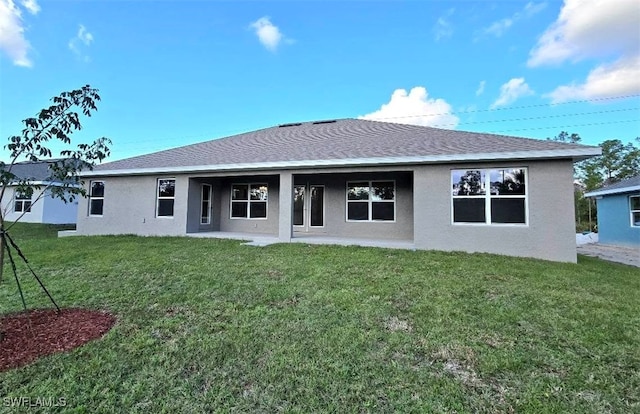 rear view of property featuring a lawn