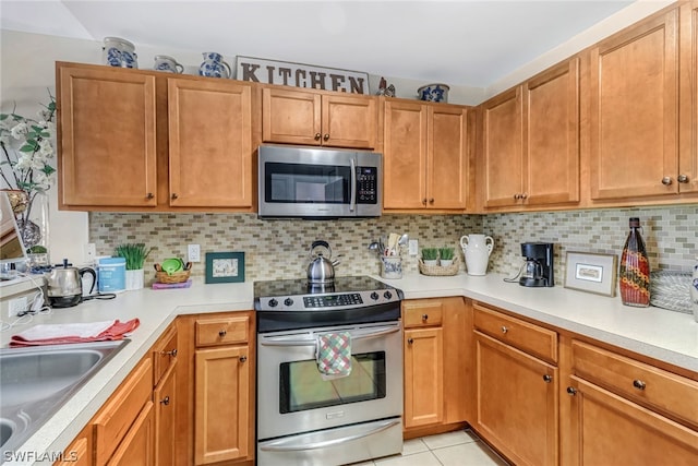 kitchen with decorative backsplash, sink, light tile patterned floors, and stainless steel appliances