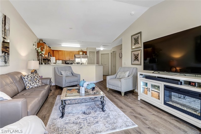 living room featuring light hardwood / wood-style floors and vaulted ceiling