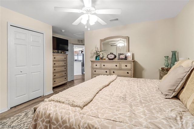 bedroom with ceiling fan, wood-type flooring, and a closet