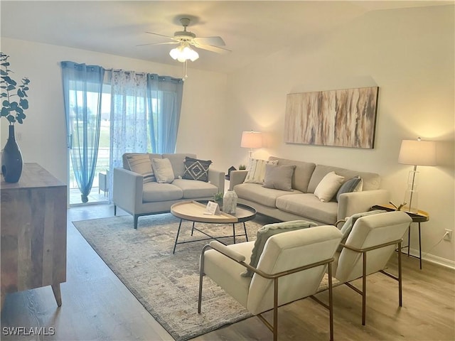 living room with ceiling fan, vaulted ceiling, and light hardwood / wood-style floors