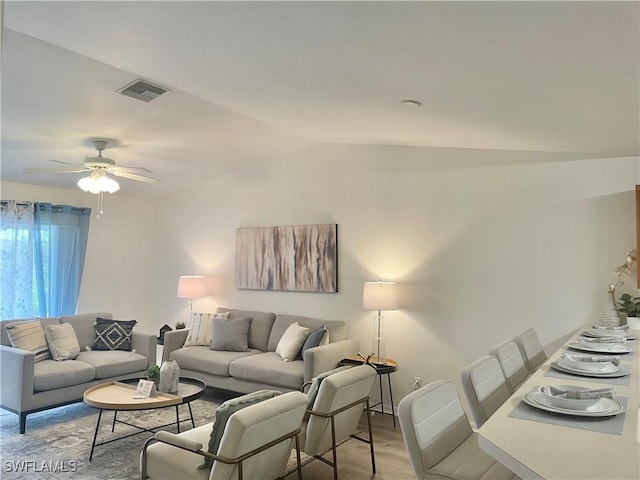 living room featuring lofted ceiling, light hardwood / wood-style floors, and ceiling fan