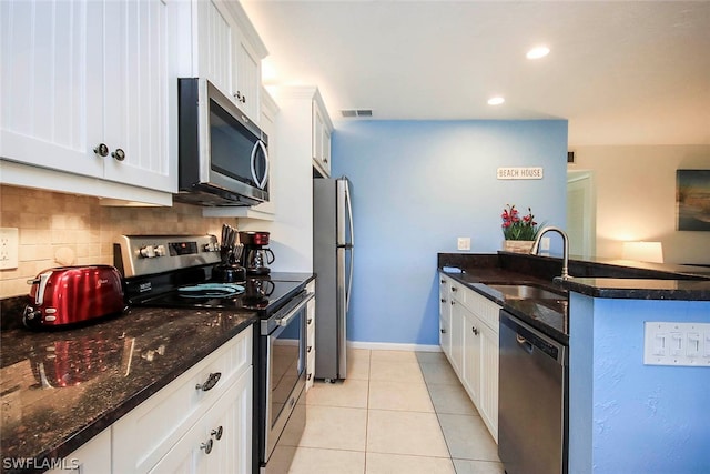 kitchen with backsplash, white cabinetry, appliances with stainless steel finishes, sink, and light tile floors