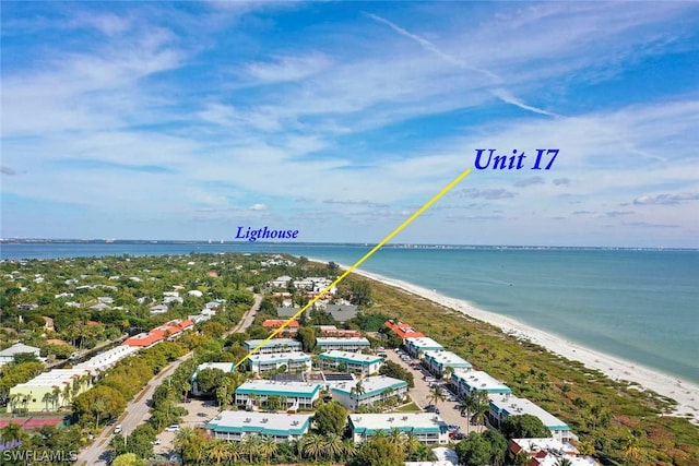 birds eye view of property with a water view and a beach view