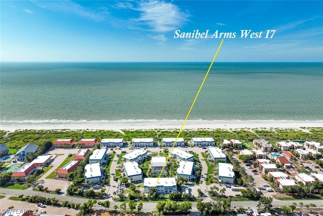 drone / aerial view featuring a beach view and a water view