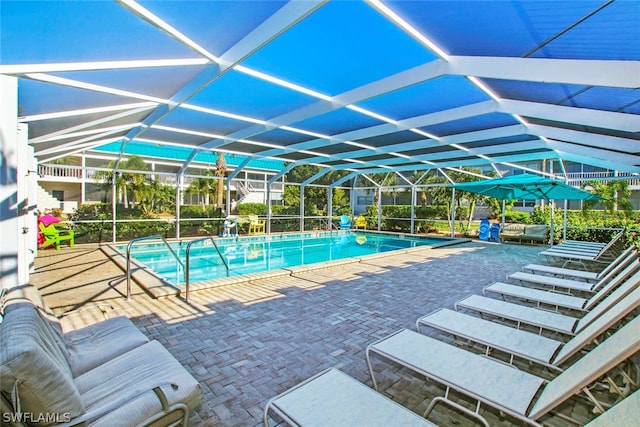 view of swimming pool featuring glass enclosure and a patio area