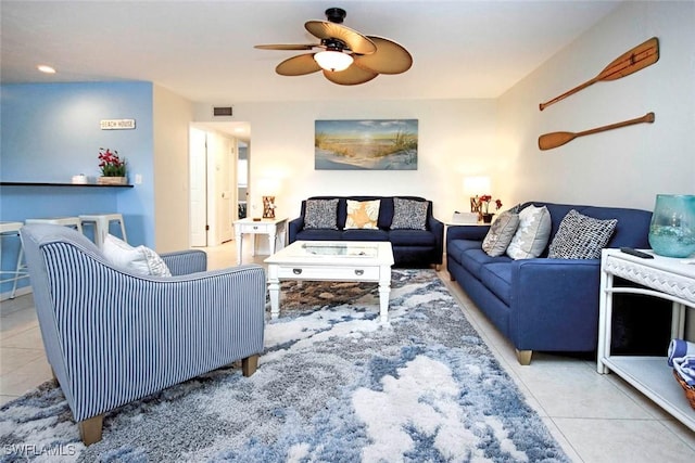 living room featuring tile patterned flooring, visible vents, and ceiling fan