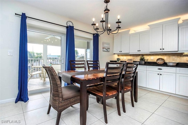 dining room featuring a notable chandelier, baseboards, and light tile patterned floors