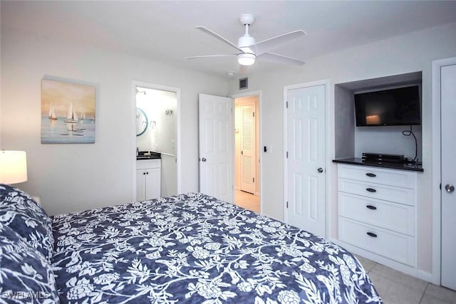 bedroom with visible vents, ensuite bathroom, a ceiling fan, and light tile patterned flooring