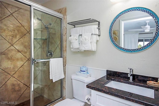 bathroom with a ceiling fan, a stall shower, vanity, and toilet