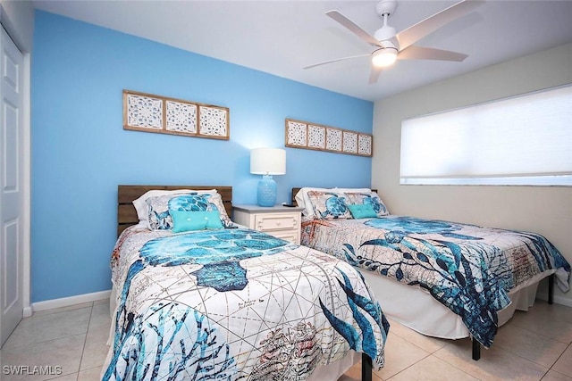 bedroom with baseboards, a ceiling fan, and light tile patterned flooring