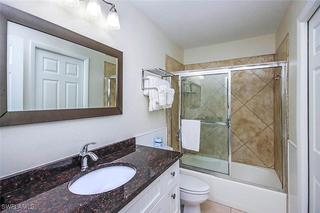 full bath with toilet, bath / shower combo with glass door, and vanity