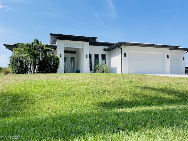 view of front of house featuring a garage and a front lawn