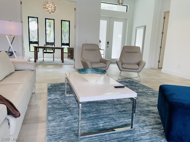 living room featuring french doors and a chandelier