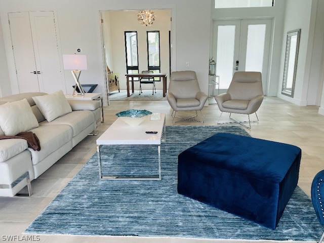 living room featuring french doors, a notable chandelier, and a healthy amount of sunlight