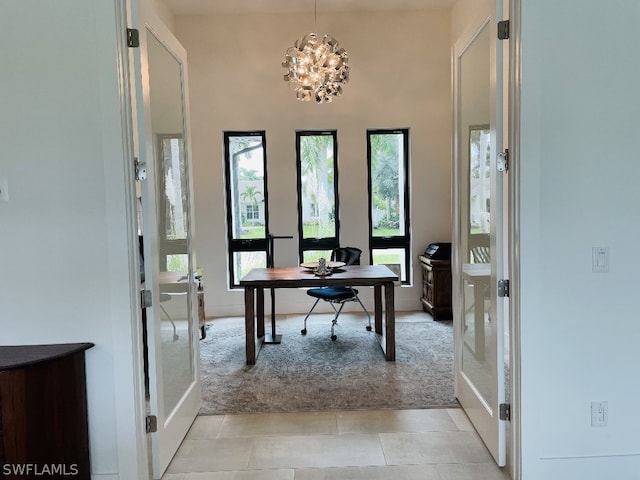 office space with a chandelier, light tile patterned floors, and french doors