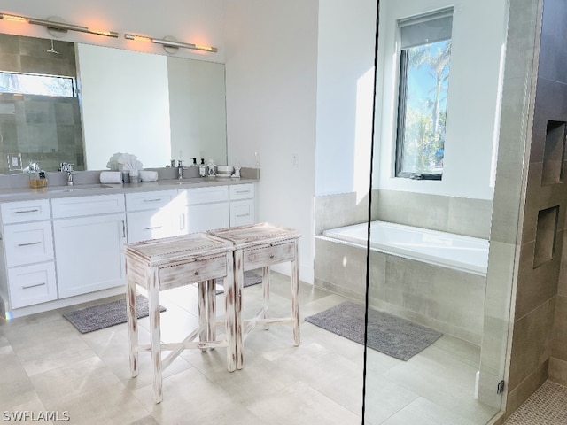 bathroom featuring plus walk in shower, vanity, and tile patterned flooring